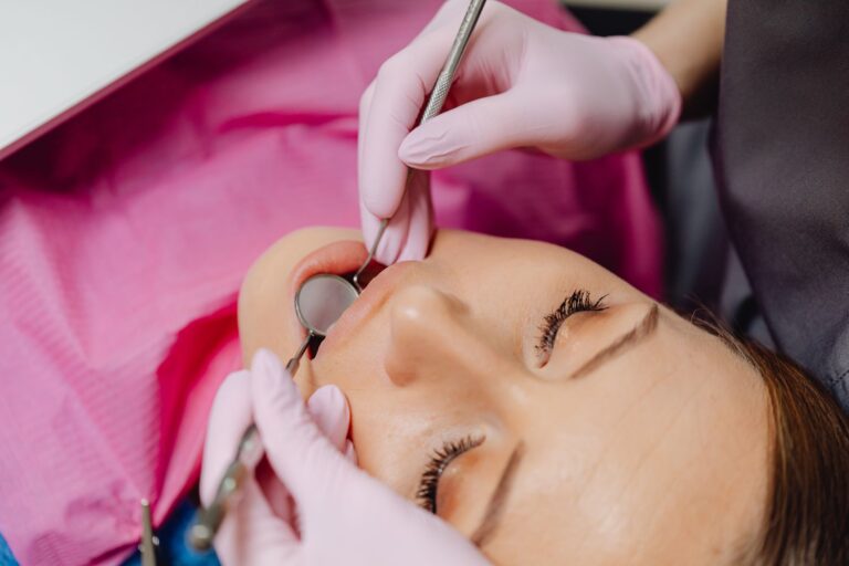 Odontólogo revisando las encías de una paciente para valorar un curetaje dental y su precio
