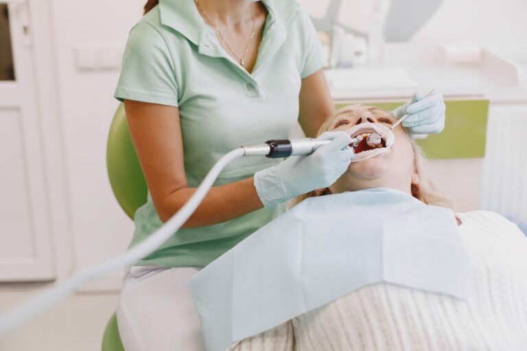 Higienista realizando una limpieza dental a un paciente en la consulta