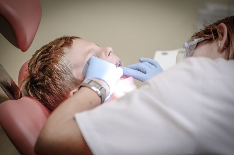 Dentista revisando caries en dientes de leche a un niño